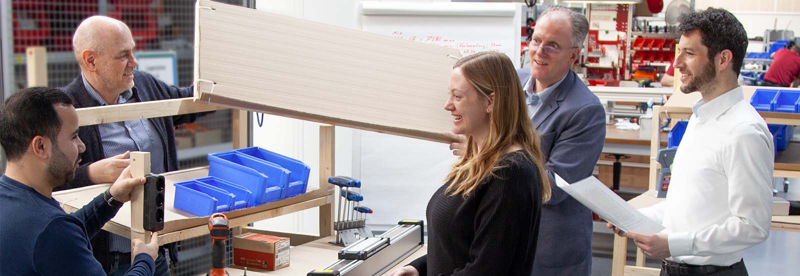 Personen die einen LEAN Workshop an einem Cardboard-Modell durchführen