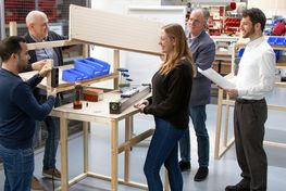 Ein Team erarbeitet das Carboard-Modell während eines LEAN-Solution Workshops